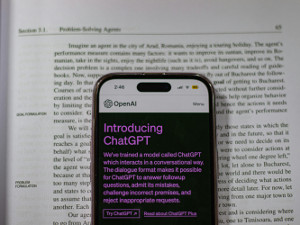 Smartphone mit ChatGPT liegt auf gedrucktem Text