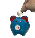 Hand wirft Münze in Sparschwein
